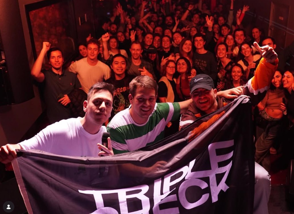 Triple Check: indoor venue, band with TRIPLE CHECK flag and audience